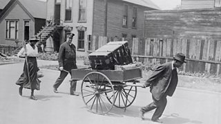 Police officer escorts Black American family moving house after the 1919 Chicago riots