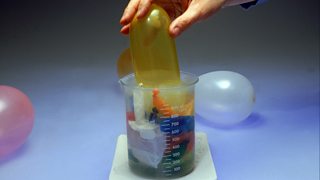 Balloons being placed inside a beaker of liquid nitrogen and shrinking.