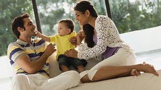 Parents with baby son relaxing in living room