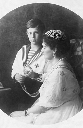 Formal portrait of youth in sailor suit posing with older woman