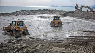 Bulldozers moving sand during beach nourishment