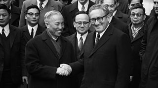 Image of Henry Kissinger shaking hands with Le Duc Tho at the Paris Peace Accords, January 1973