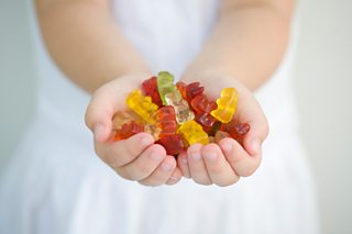 Child with a handful of sweets