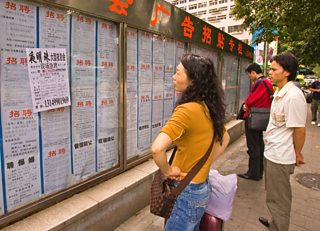 Unemployed people looking at job advertisements in the city of Shenzhen, China