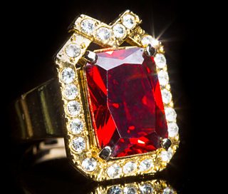 A gold ring with precious red stone