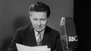 Black and white photo of Richard Baker reading the BBC News in March 1954