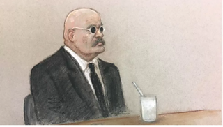 A court sketch of prisoner Charles Bronson shows him in black suit and tie, wearing a white shirt.