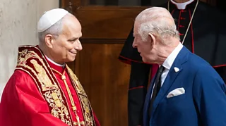 Pope Leo shakes hands with King Charles.
