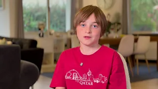 Boy in a red top looking to camera.