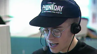 Man in a ‘Phone Day’ baseball hat working in a call centre.