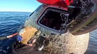 Orion capsule hatch door being opened