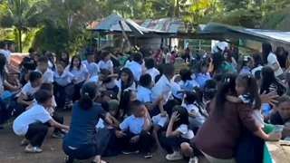 Children at a school in the Philippines shelter after an earthquake strikes, causing an outdoor structure to collapse