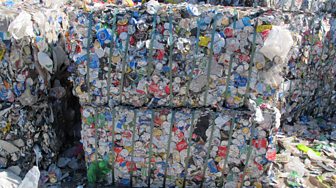 Used drink cans stacked at the recycling facility.