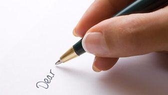 A hand holds a pen, the word 'Dear' is written on a piece of paper