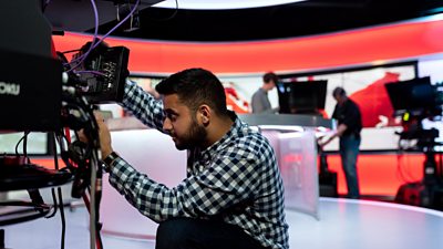 BBC apprentice operating a camera in a studio