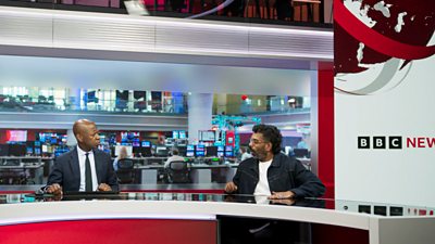 Clive Myrie and Romesh Ranganathan sit at opposite ends of the BBC News desk