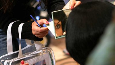 make-up artist holding up a mirror