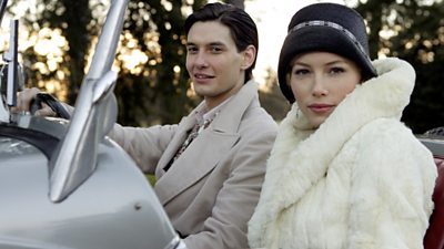 Ben Barnes and Jessica Biel in 1920s costume in an open topped sports car