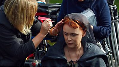 make-up artist uses a comb to arrange hair