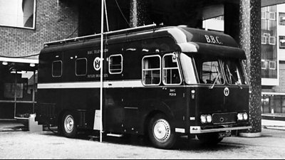 A large van, rather like a horsebox. The side says BBC Television Outside Broadcasts with the BBC coat of arms. It has a large aerial on the side.