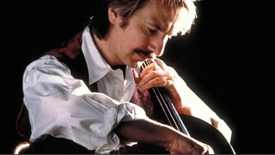 A mustachioed Alan Rickman plays the cello