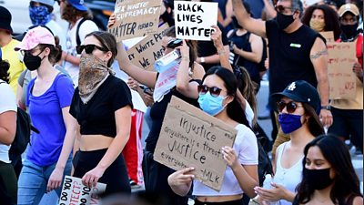 Woman holds injustice placard at a BLM rally