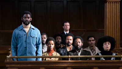 A black man stands up in court