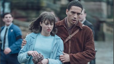 Stevie (played by Gabriel Akuwudike) leads Vivien (played by Agnes O'Casey) down the street in Ridley Road.