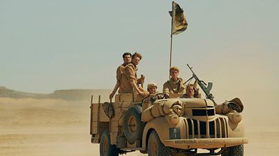 SAS Rogue Heroes - a group of young men in a large 4x4 vehicle drive across the desert
