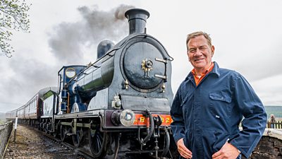 Michael Portillo smiling in front of steam train