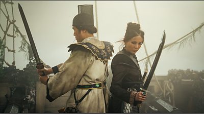 Ji Hun (Arthur Lee) and Madam Ching (Crystal Yu) stand back to back on the deck of a ship, wielding their weapons