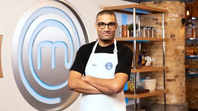 Richie Anderson wearing masterchef apron with masterchef m in background