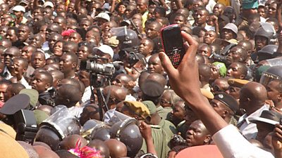 A huge crowd at the debate - people are filming. There are some riot police in the crowd