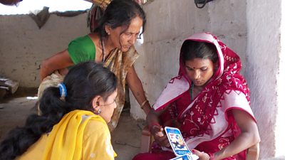A community health worker on a visit to a family with the mobile phone service Mobile Kunji.