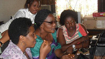 Ifeoma shows colleagues how digital audio editing works.