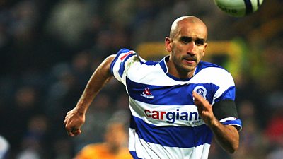 Zesh Rehman running on the pitch. Wearing a blue and white strip with cargiant on it and a black armband.