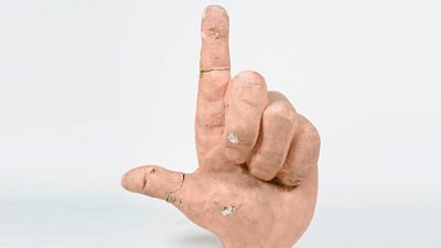 A plaster hand with a finger pointing up, now rather grubby