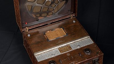 A suitcase-styled radio in brown wood.