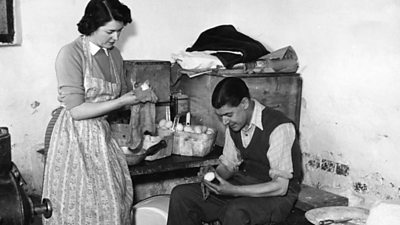 A 1950s farmers wife wearing an apron examines some eggs with her husband.