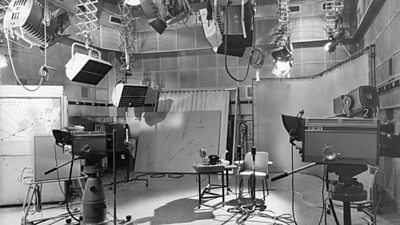 The weather studio - a large number of charts and maps, two cameras, and various lights and cables.