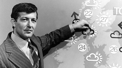 Bill Giles sticking on one of the magnetic weather symbols showing rain. He looks a bit cross. 