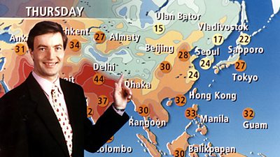 David Braine in front of a map of Asia. By contrast to the UK maps, the temperatures are very high showing orange and red. 44 degrees in Delhi. 