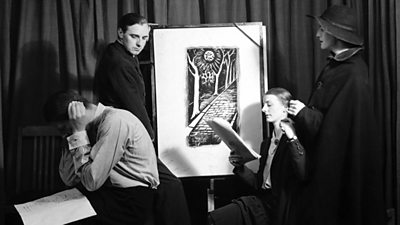 Four actors gathered around a painting