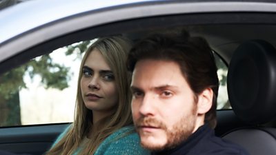 Cara Delevingne looks suspiciously at Daniel Brühl in a car