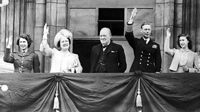 Left to right: The Queen (then Princess Elizabeth), Queen Elizabeth (later Queen Mother), Sir Winston Churchill, King George VI and Princess Margaret wave to the crowds from a balcony. 