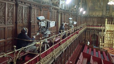 Two full-size broadcast cameras with cameramen are up on the balcony in the House of Lords