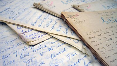 A pile of handwritten documents on a desk.