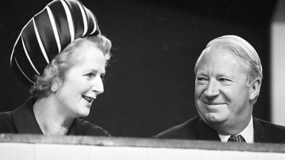 Margaret Thatcher in a big hat. Edward Heath looks at her suspiciously.