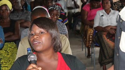 A lady asks a question during a community debate in Zambia