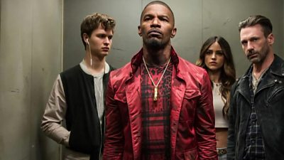 Three men and a woman standing - a scene from Baby Driver